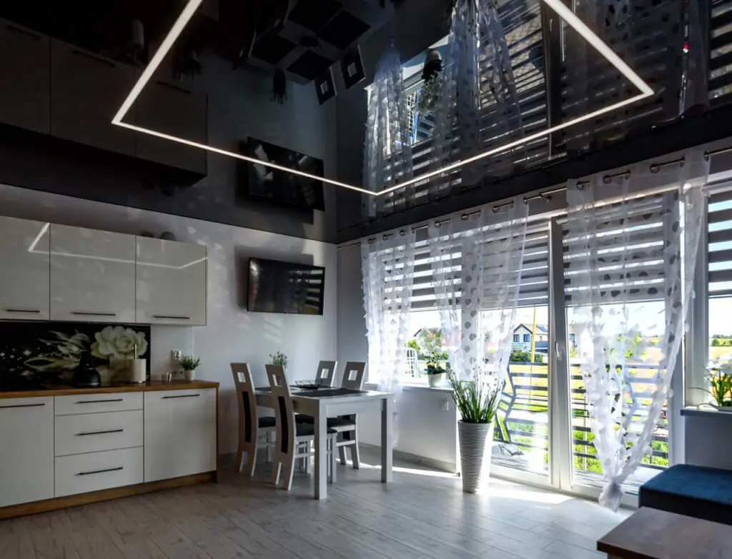 Nowoczesna kuchnia z jadalnią i dużymi oknami.